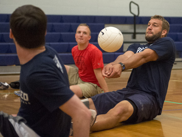 Max Rohn sets the ball during a game of seated volleyball.